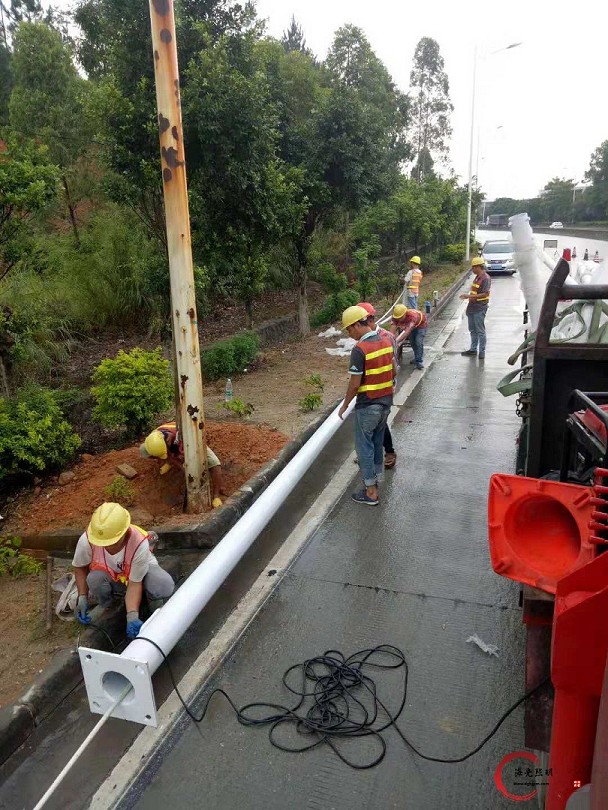 海光照明安装人员为了不延误工期，冒雨坚持安装路灯